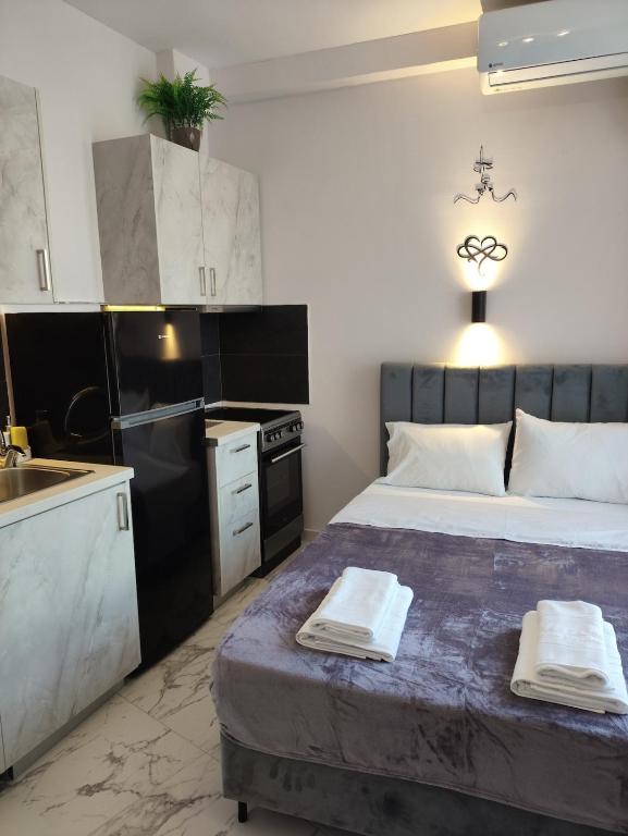 a bedroom with a large bed and a kitchen at Valaoritou Luxury Jacuzzi by Dimcol 1 in Thessaloniki