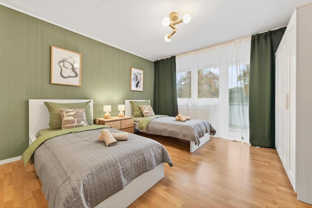 two beds in a bedroom with green walls at NEW-Tina in Buchen