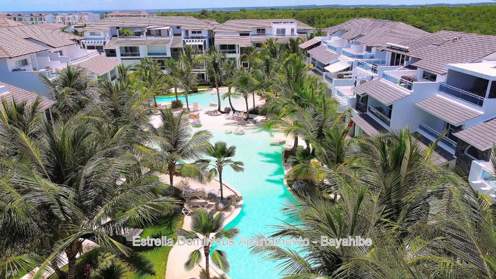 Una vista aérea de la piscina de un resort con palmeras. en Estrella Dominicus Apartamento - Bayahibe, en Bayahibe