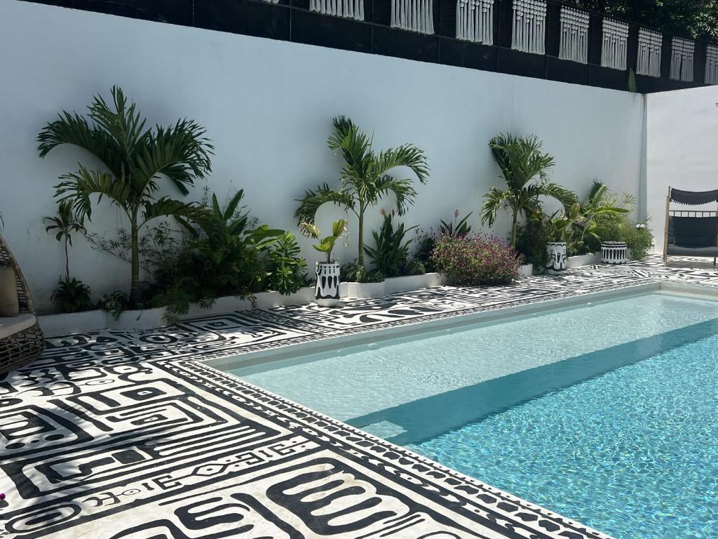 a swimming pool next to a building with palm trees at Desiree Luxury Apartamentos in Carmen