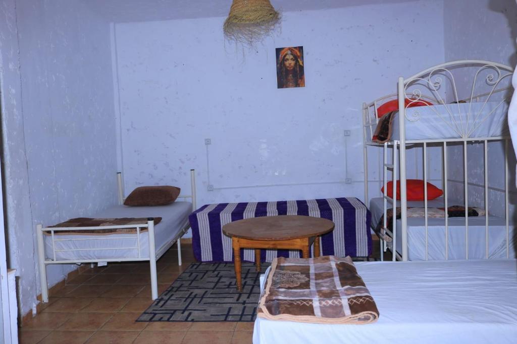 une chambre avec deux lits superposés et une table dans l'établissement TISLIT Surf Taghazout, à Taghazout