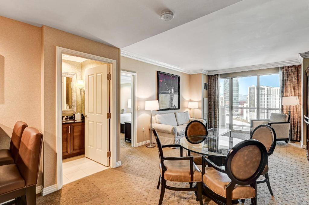 a living room with a table and chairs in a room at The Signature at MGM Grand, Luxury Balcony Suite, Strip View in Las Vegas