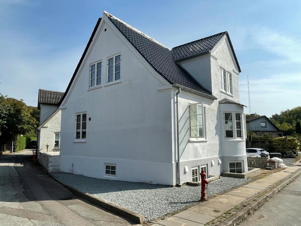 a white house with a red fire hydrant in front of it at F27-K, 4 people, 4 bedrooms, fully furnished in Aalborg