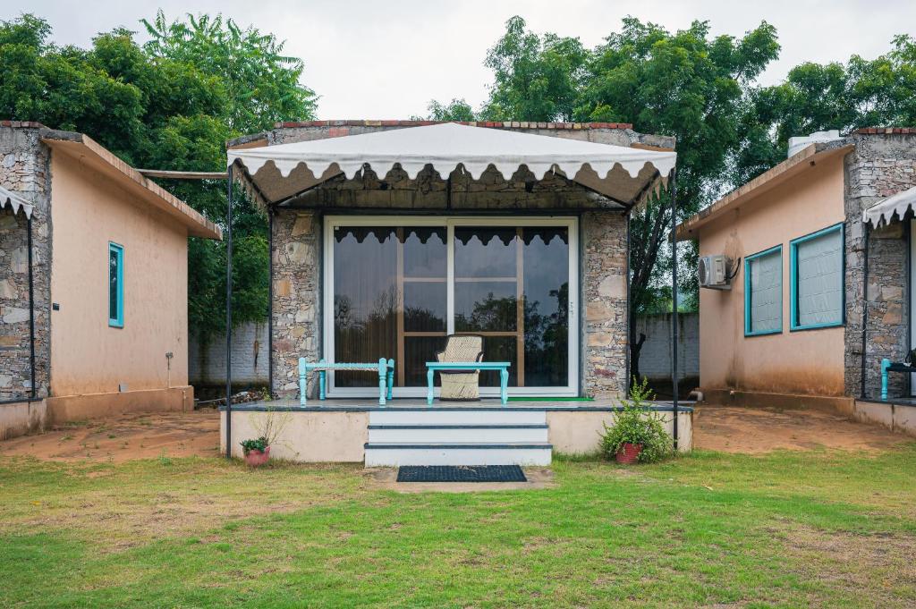 a house with a porch with a blue table on it at Hidden Gem near Jaipur horse ride, scenic view & swimming pool in Pachār