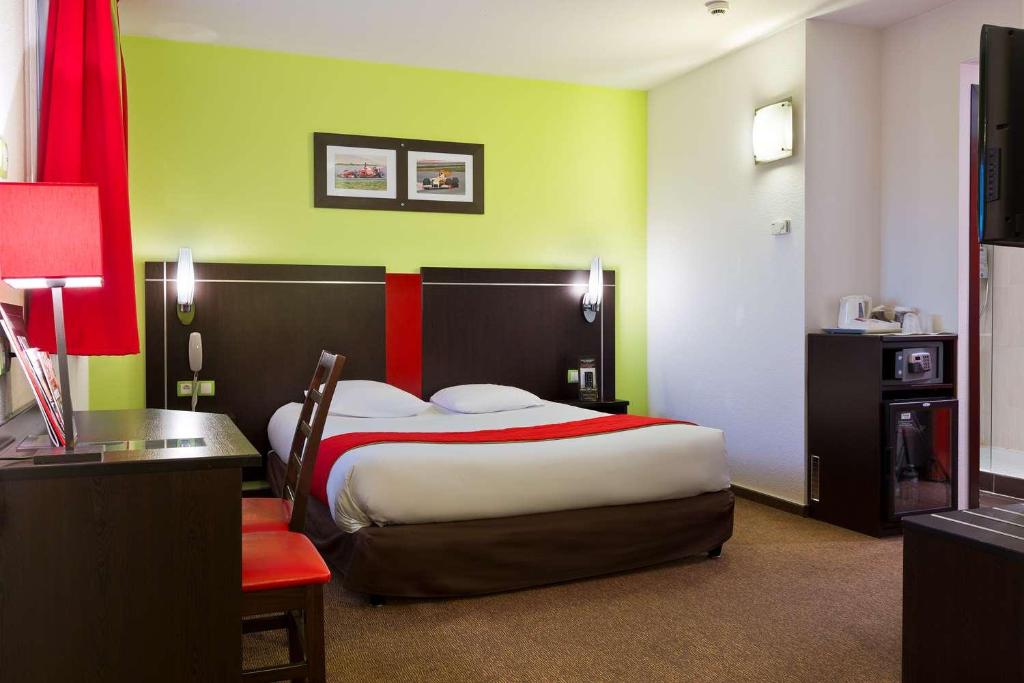 a bedroom with a bed with a red and green wall at Enzo Hotels Thionville by Kyriad Direct in Thionville