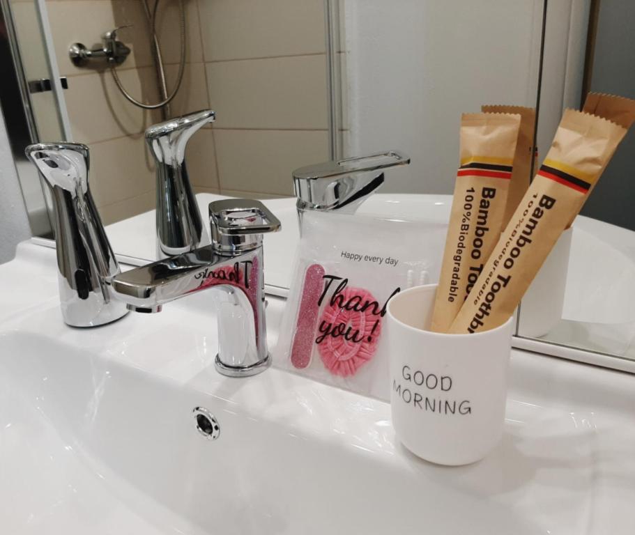 Un lavabo de baño con dos cepillos de dientes y una taza. en La Stella Bianca, en Sutri