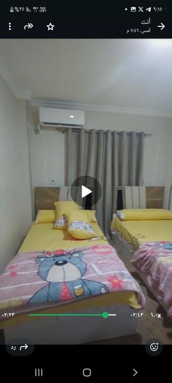 a bedroom with a bed with a teddy bear on it at غرفتين في شقة in Zayyān