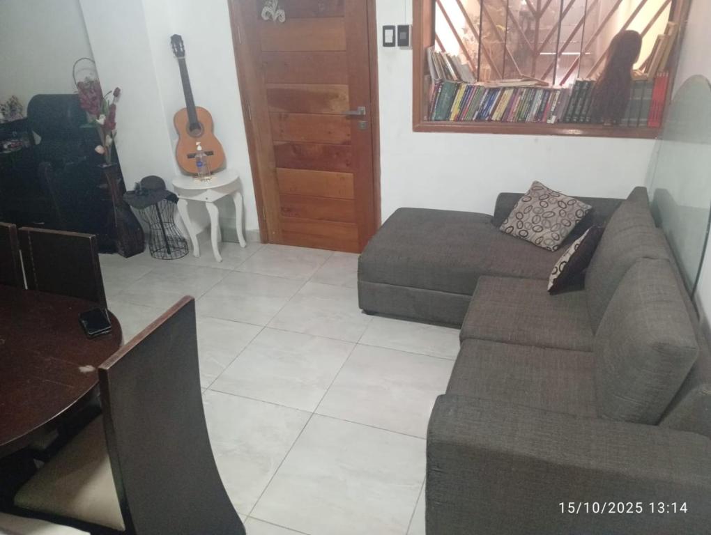 a living room with a couch and a guitar at Colibri - Hab Doble in Lima