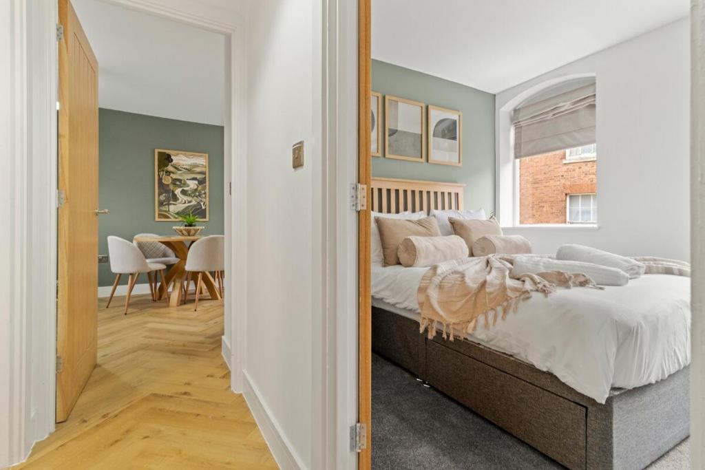 a bedroom with a bed and a dining room at Pear Tree - Stylish City Centre Apartment in Worcester
