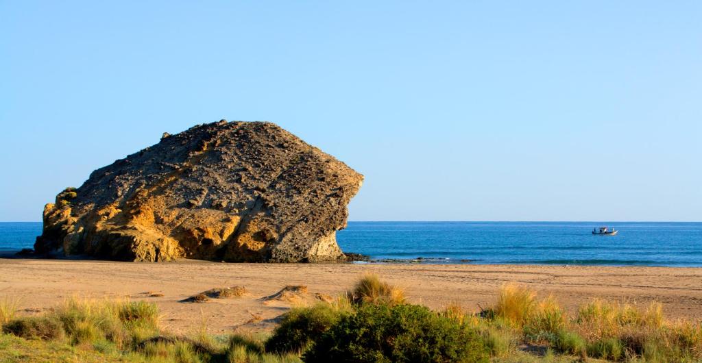 a large rock sitting on a beach next to the ocean at Doña Pakyta in San José