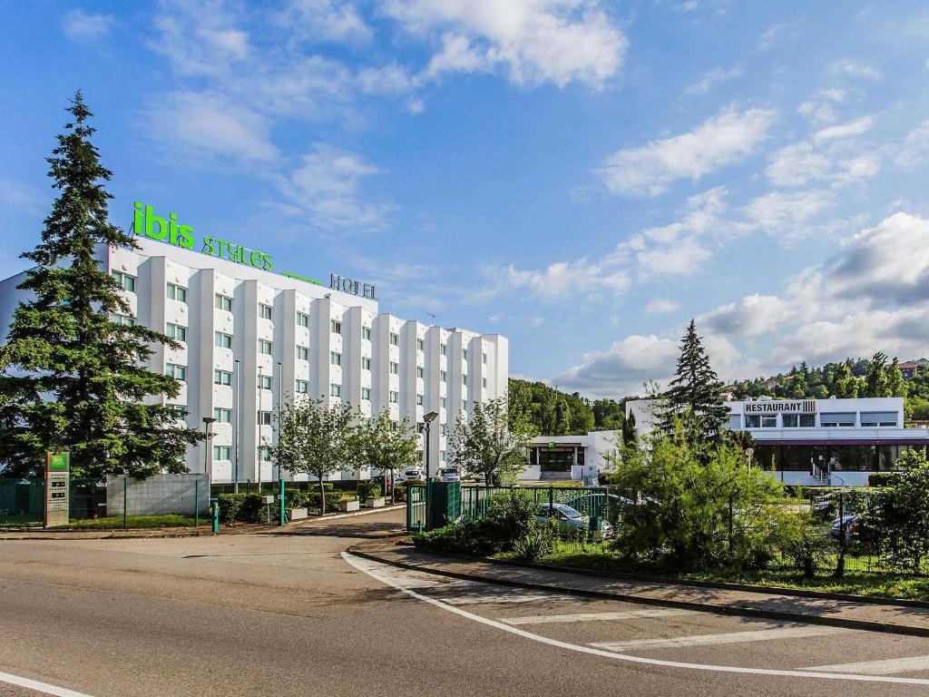 a large white building with a sign on top of it at ibis Styles Lyon Sud Vienne in Chasse-sur-Rhône
