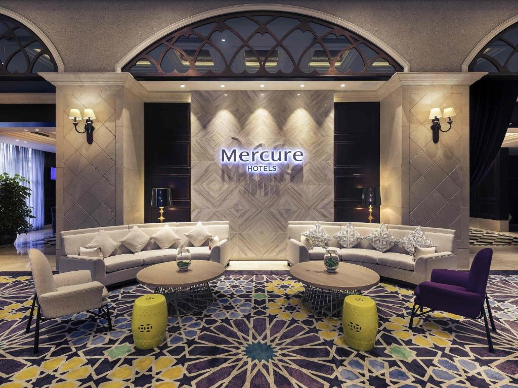 a lobby with couches and tables in a hotel at Mercure Xiamen Exhibition Centre in Xiamen