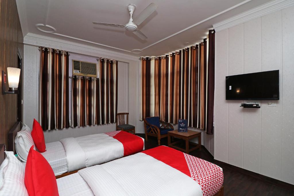 a hotel room with two beds and a flat screen tv at Super Hotel O Mehtab Regency in Rewāri