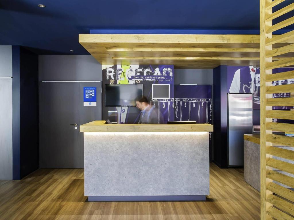 a man is sitting at a counter in a kitchen at Ibis Budget Braga Centro in Braga