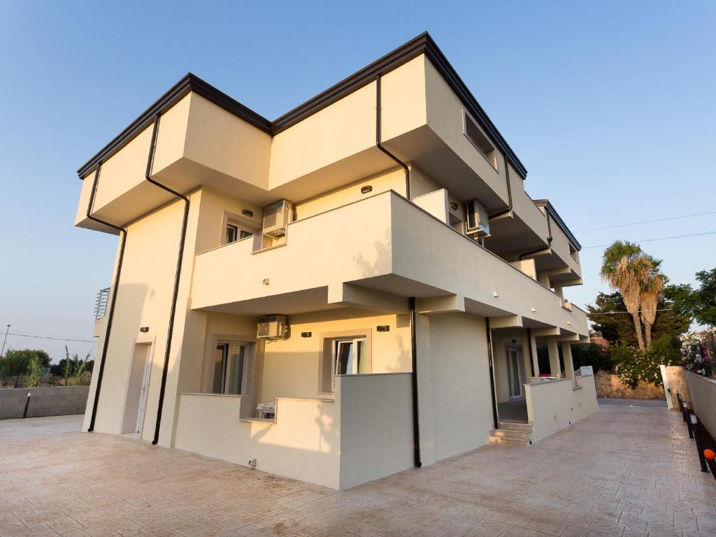 a large white building with two levels at Marea Sicula in Siracusa