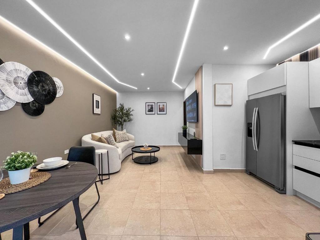 Una sala de estar con una mesa y una cocina. en Hyde Park 1 Your Comfy Apt With Parking in San Juan, en San Juan
