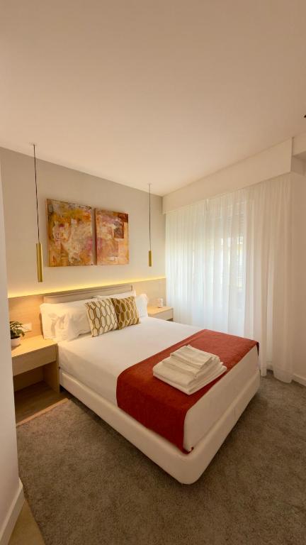 a bedroom with a large white bed and a window at Timeless - O`Clock in Lisbon