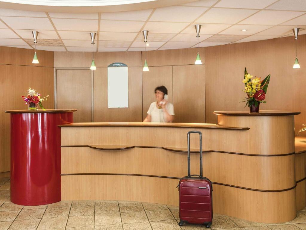 a man standing behind a bar with a luggage at ibis Auch in Auch