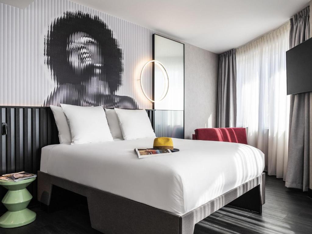a bedroom with a bed with a painting on the wall at Tribe Amsterdam City in Amsterdam