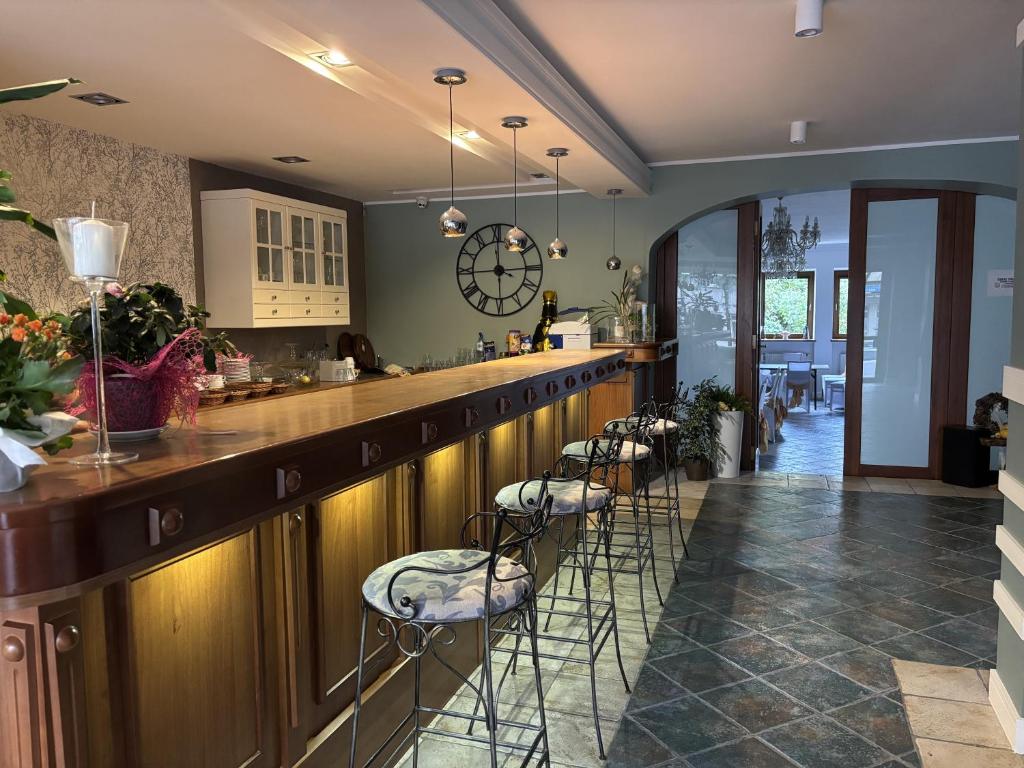 Un bar con una fila de taburetes en una habitación. en Gościniec Witomino, en Gdynia
