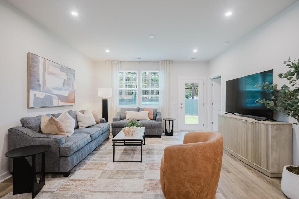 a living room with a couch and a tv at Spacious Bluffton Retreat for Families & Friends in Bluffton
