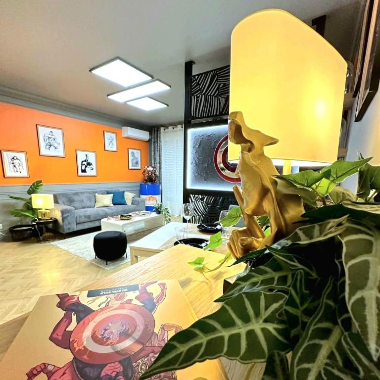 a living room with a couch and a table at Le QG des Super Héros Marvel in Nevers