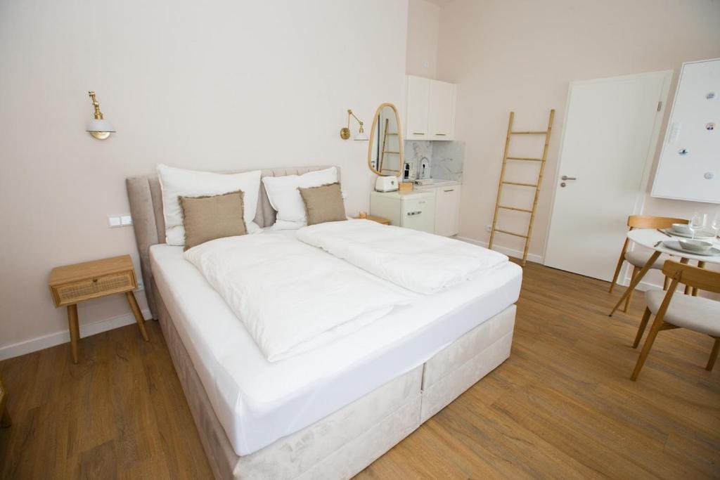 a large white bed in a room with a table at Apartment am Michel mit Parkplatz in Hamburg