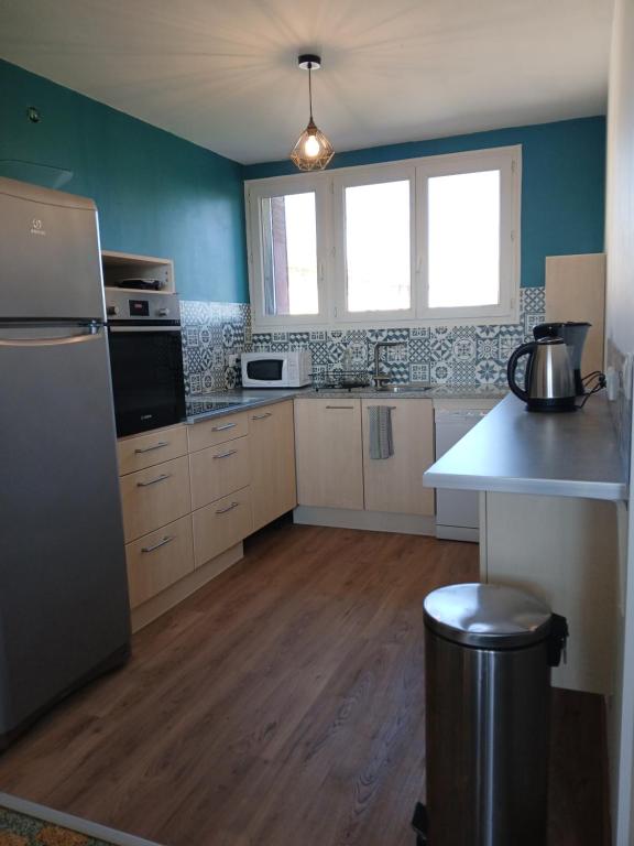 a kitchen with a refrigerator and a stove top oven at gite isolée proche futuroscope Airvault in Saint-Clair