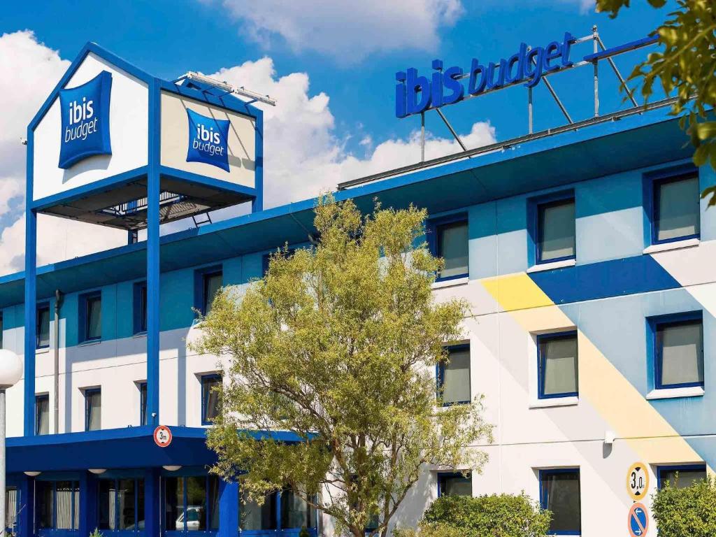 シェーネフェルトにあるibis budget Berlin Airport Schönefeldのホテルの看板がある建物