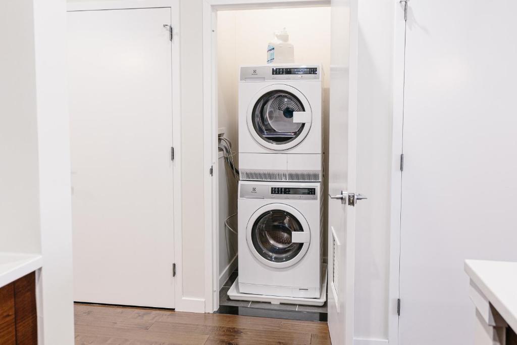 eine Waschküche mit zwei Waschmaschinen und Trocknern in der Unterkunft Kislak 404 Luxurious 1BR in Heart of Downtown in Newark