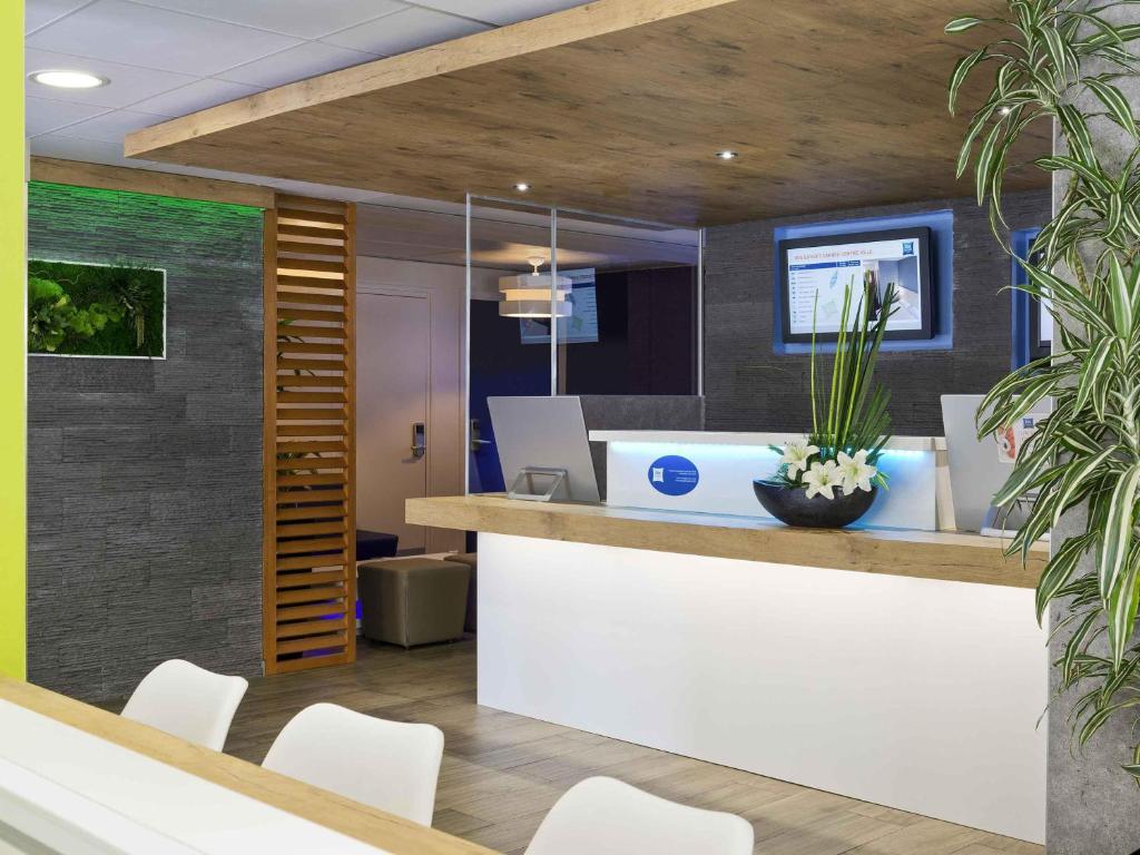 an office with a reception desk with white chairs at ibis budget Cannes Centre Ville in Cannes