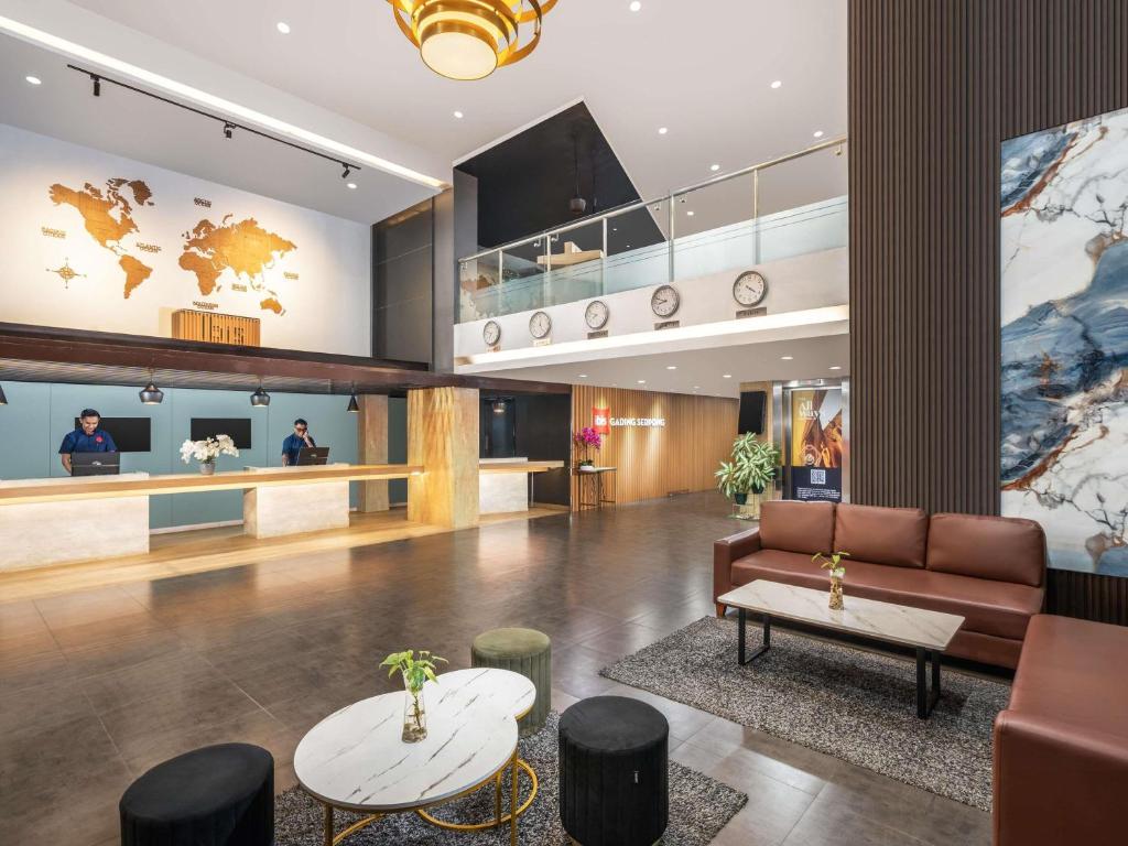 a lobby of a hotel with a couch and a table at Ibis Gading Serpong in Serpong