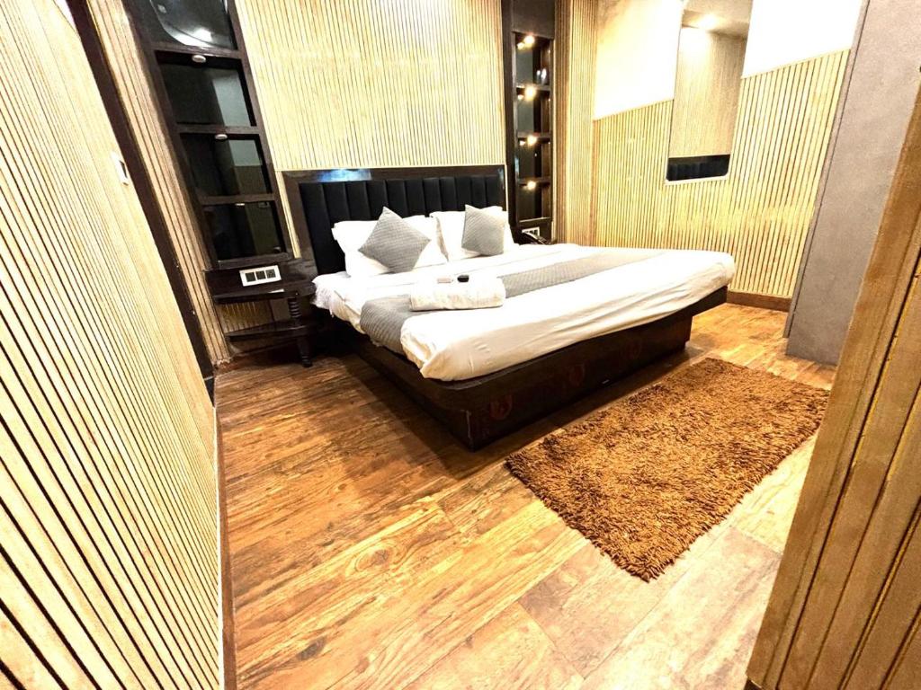 a bedroom with a large bed with white sheets and pillows at Hotel Red Stone - 3 Mins from Railway Station and 5 Mins from Metro in New Delhi