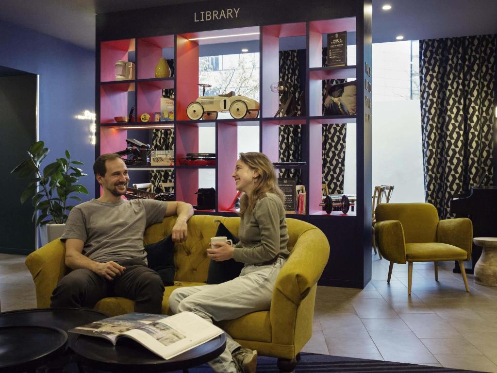 a man and woman sitting on a couch in a store at Aparthotel Adagio Annecy Centre in Annecy