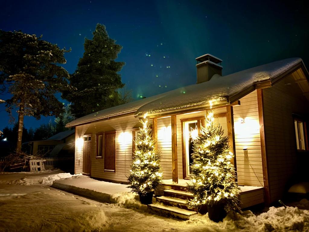 a house with christmas trees and lights on it at Luxury City Cottage in Rovaniemi