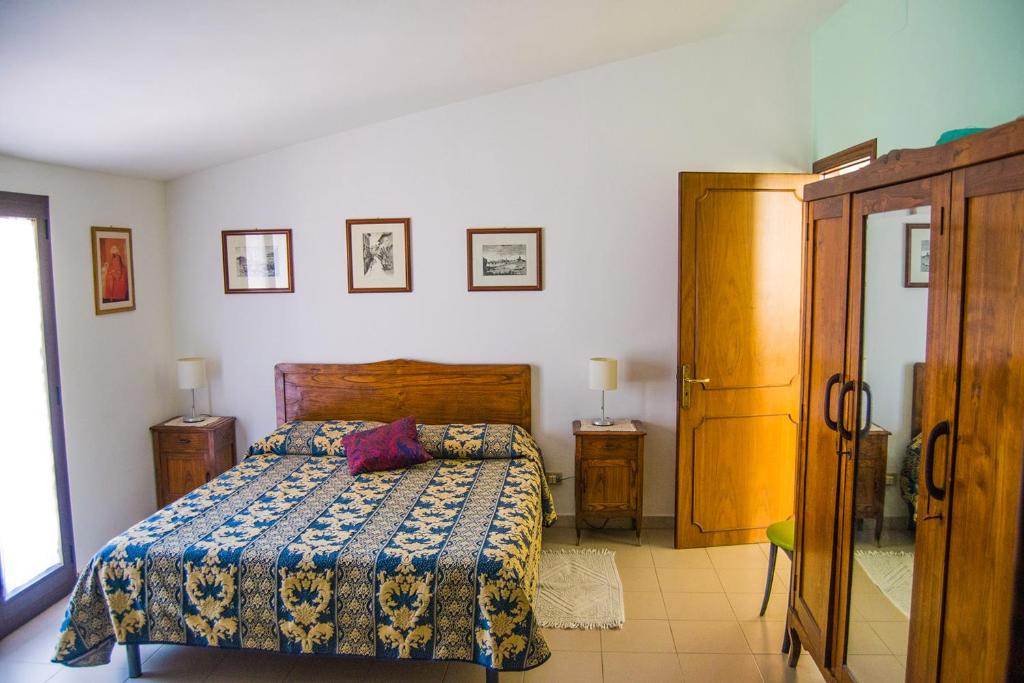 a bedroom with a bed with a blue comforter at B&B Cactus in Giardini Naxos