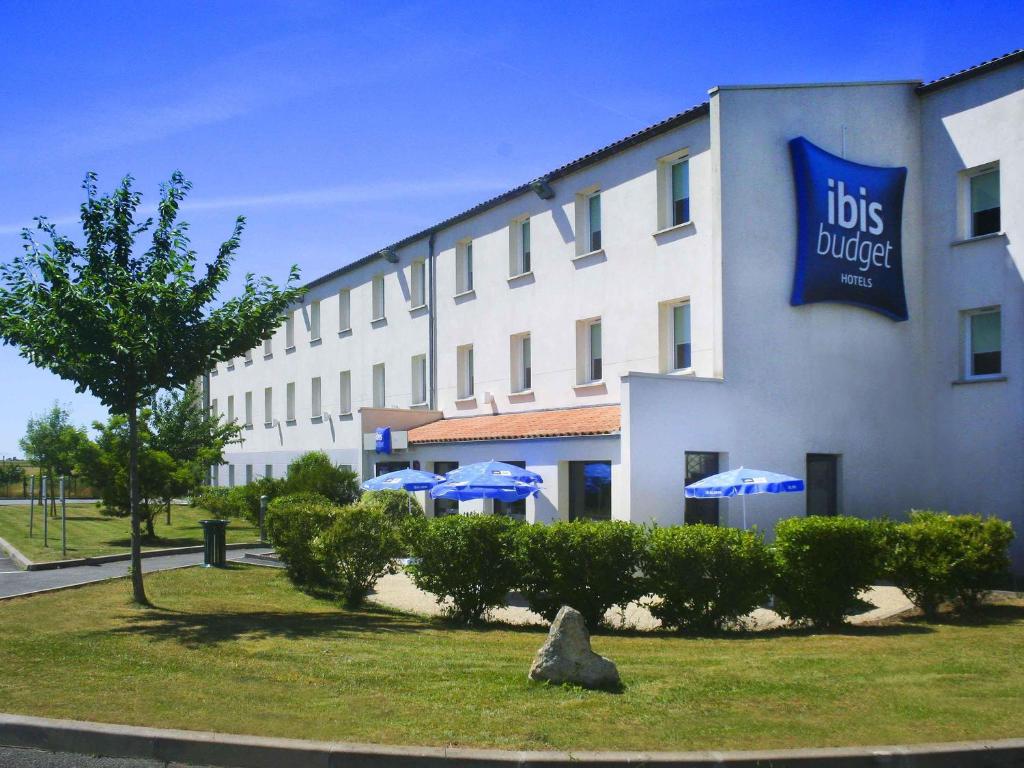 a hotel with a sign on the side of a building at ibis budget Niort - La Crèche in La Creche