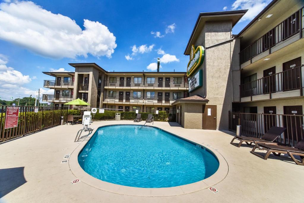 une piscine en face d'un hôtel avec un bâtiment dans l'établissement Masters Inn Tucker, à Tucker