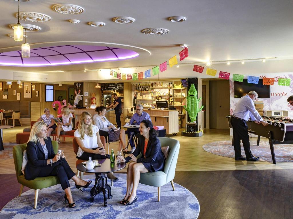 レスキンにあるHôtel Mercure Lille Aéroportの椅子に座る人々