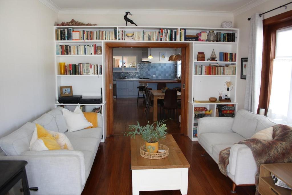 a living room with two white couches and a table at Hearth House - Character Family Home in Hastings