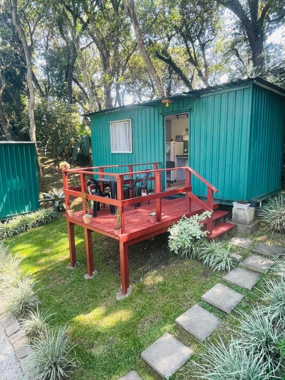 a green and red house with a wooden deck at Tiny House Passaúna - Climatizado, deck e parque in Curitiba
