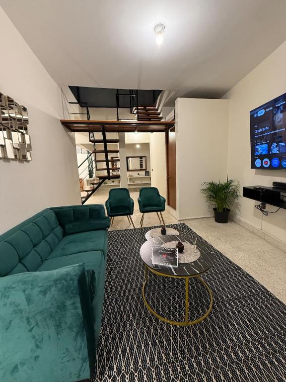 a living room with a green couch and a table at Estancia pino suarez in Xalapa