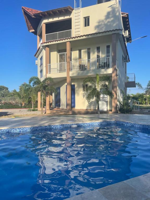 a house and a swimming pool in front of a building at Jeda Village in Higuey