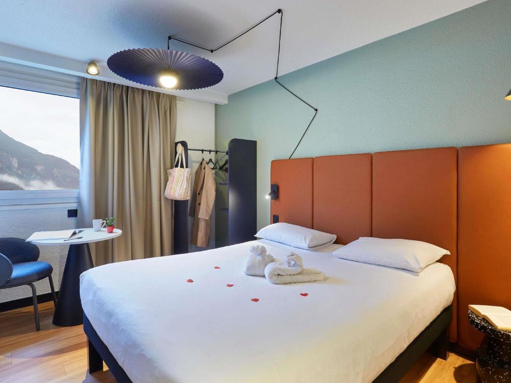 a bedroom with a large bed with towels on it at Ibis Sallanches Porte du MontBlanc in Sallanches