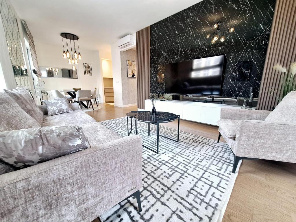 a living room with a couch and a tv at Belgrade Waterfront Sky & River View Residences in Belgrade