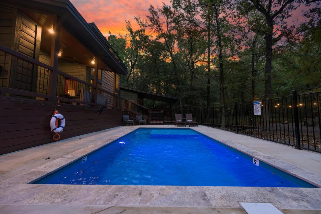 uma piscina no quintal de uma casa em Wine Time 5 Bedroom Shuffleboard Hot Tub Fire Pit Play Set em Broken Bow
