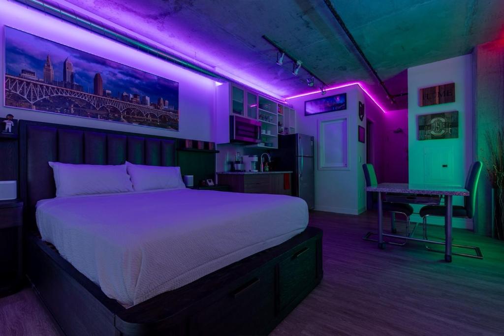 a bedroom with a bed with purple lights on it at Luxury Apt In The Heart Of The Theater District in Cleveland