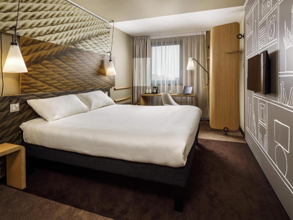 a hotel room with a large bed and a television at ibis Cambridge Central Station in Cambridge