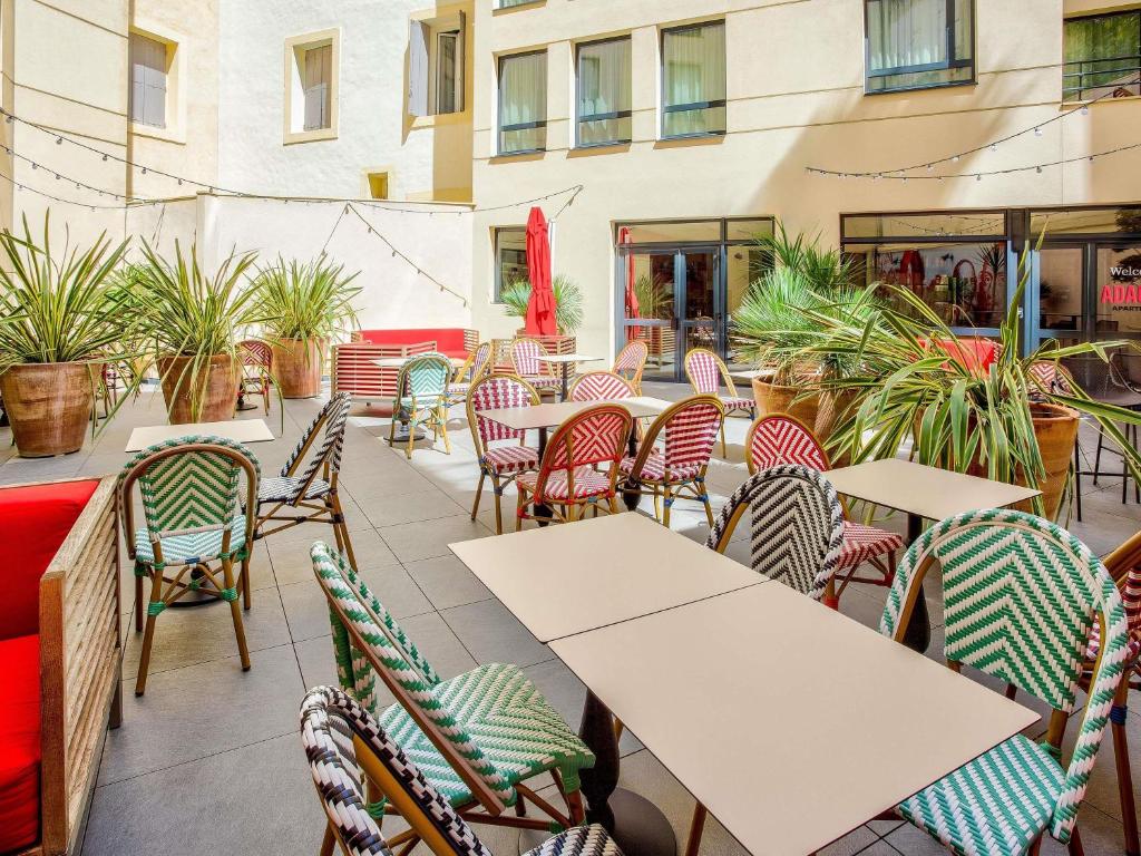 an outdoor patio with tables and chairs and plants at Aparthotel Adagio Montpellier Centre Comedie in Montpellier