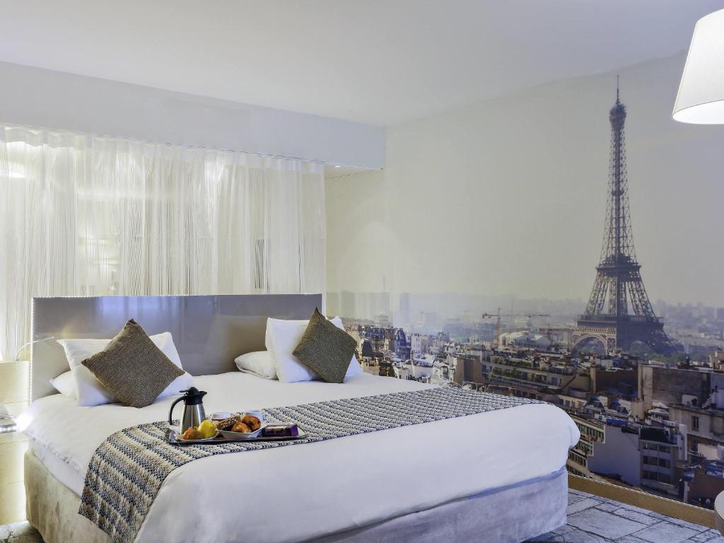 a bedroom with a bed with a view of the eiffel tower at Mercure Paris Vaugirard Porte De Versailles in Paris